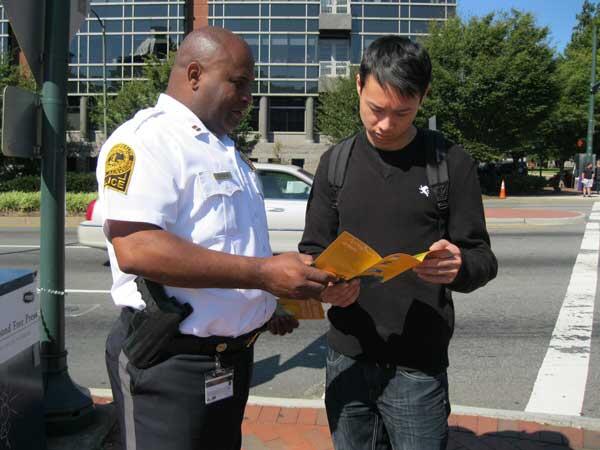 Captain Jeffrey Goodson goes over road safety information with VCU senior Dominici Nguyen. Pedestrians should walk left, facing traffic when a road has no sidewalk and cross at crosswalks. 
