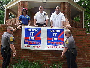 Better buckle up!  VCU Police kicked off the promotional phase of the “Click It or Ticket” campaign by hanging banners, posting signs and adding vehicle magnets to boost awareness.  First row:  Officer Doug Dawson (left) and Cpl. Rebecca Ellison (right) and second row (from left) Sgt. Nicole Dailey, Cpl. Marvin Wingo and Cpl. Jonathan Siok. Photo by Mike Porter, VCU Office of Communications and Public Relations.