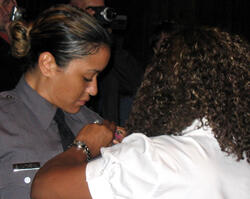 VCU Police Academy graduate Brandy Matthews (left) receives a badge from her grandmother Linda White at the conclusion of the VCU Police Basic Academy graduation exercises.  Matthews also received the “Best Combined Achievement” award. Photo by: Mike Porter/ VCU News Services