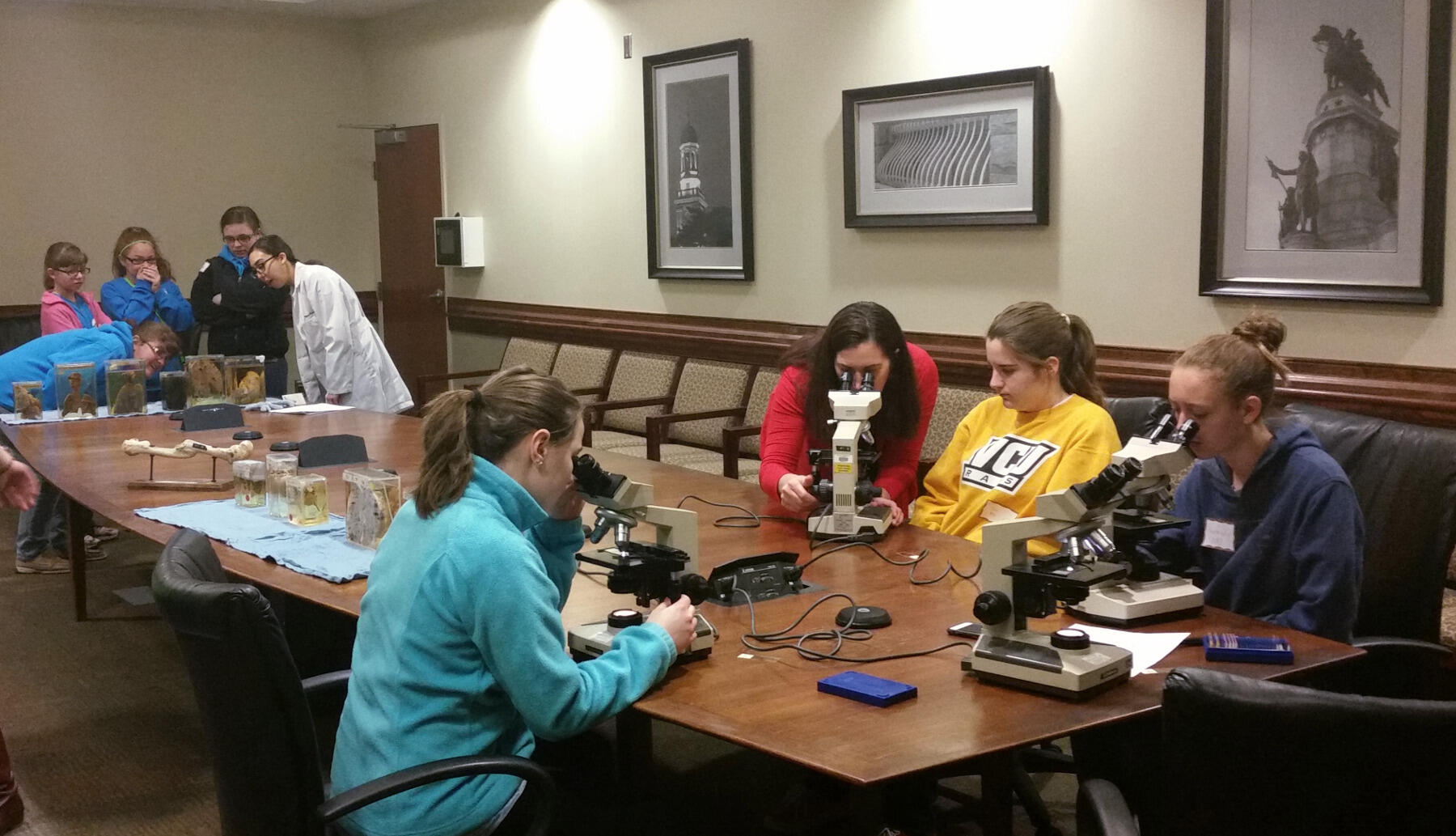 During a pathology rotation, Girl Scouts (at right) learned to use a microscope to visually observe differences between healthy and unhealthy human cells while others (at left) looked at organs from patients with different conditions. Photo by Ayana Scott-Elliston.