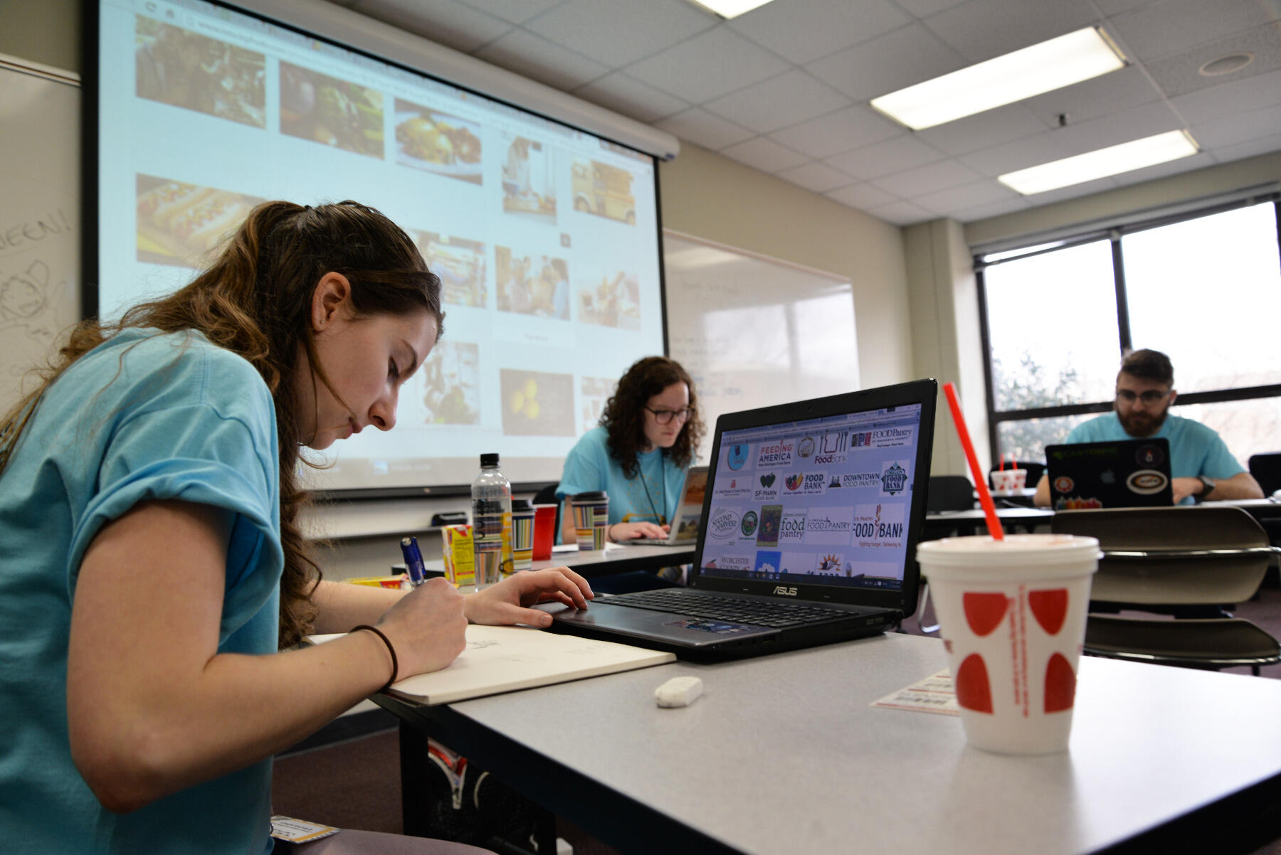 Jackie Houle, a junior creative advertising major, works with teammates to create marketing material for Colonial Heights Food Pantry.