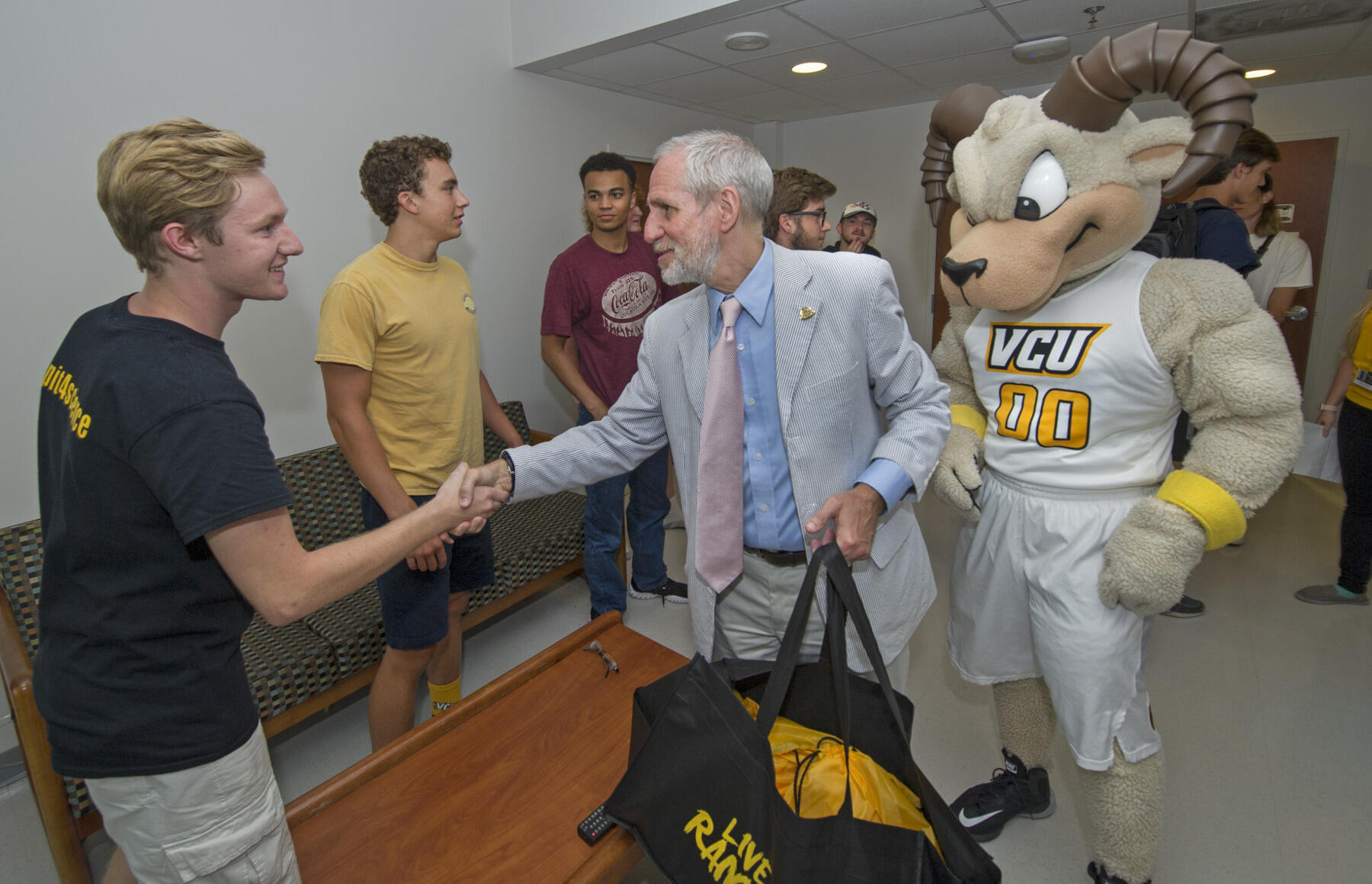 Charles Klink and Rodney the Ram welcome a group of freshmen students during House Calls. 