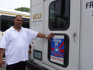 Campus vehicles will also be part of the publicity campaign.  Here, Cpl. Marvin Wingo puts a sign on the back of a security escort service van.  Photo by Mike Porter, VCU Office of Communications and Public Relations.