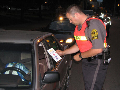 Education was a key component of the “Click It or Ticket” campaign.  Here, Corporal John Siok, traffic enforcement supervisor, hands out educational materials to a driver passing through the checkpoint. Photo provided by Officer Michael Roser, VCU Police Department. 