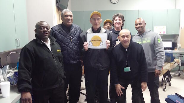 (Back row, from left) Ronnell Howard, LouAnn Jones and Michael Brice. (Front row, from left) Kokouvi Agle, Luis Olivieri, James LaPenta and David Horne. LaPenta, standing with the sign, serviced the 500,000th RamSafe ride request.