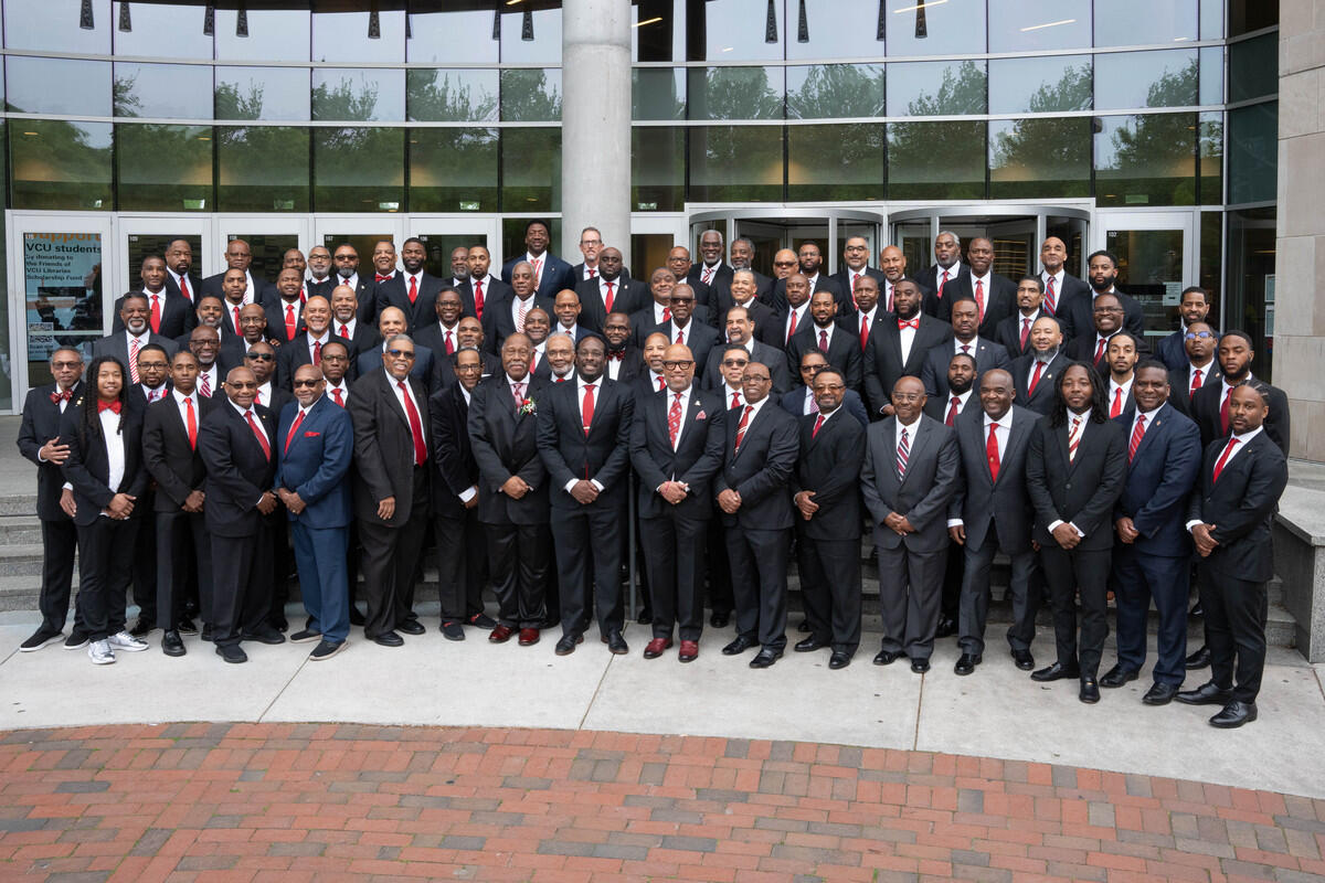 A group photo of more than 70 men in suits and ties. 