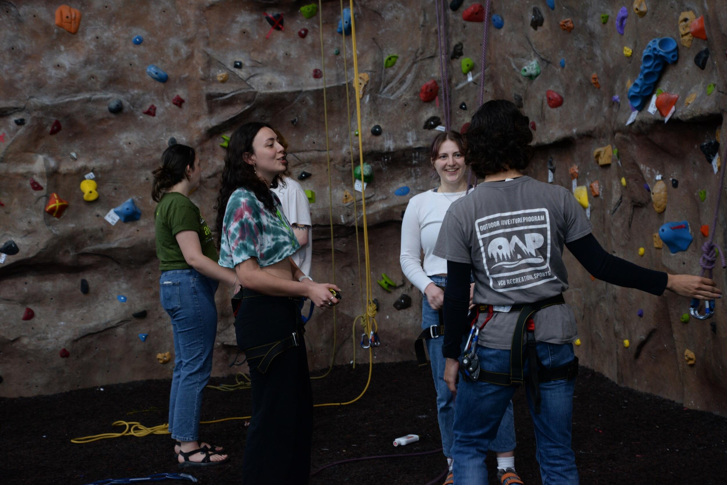 A group of students standing in front of the rock wall at the Cary Street Gym