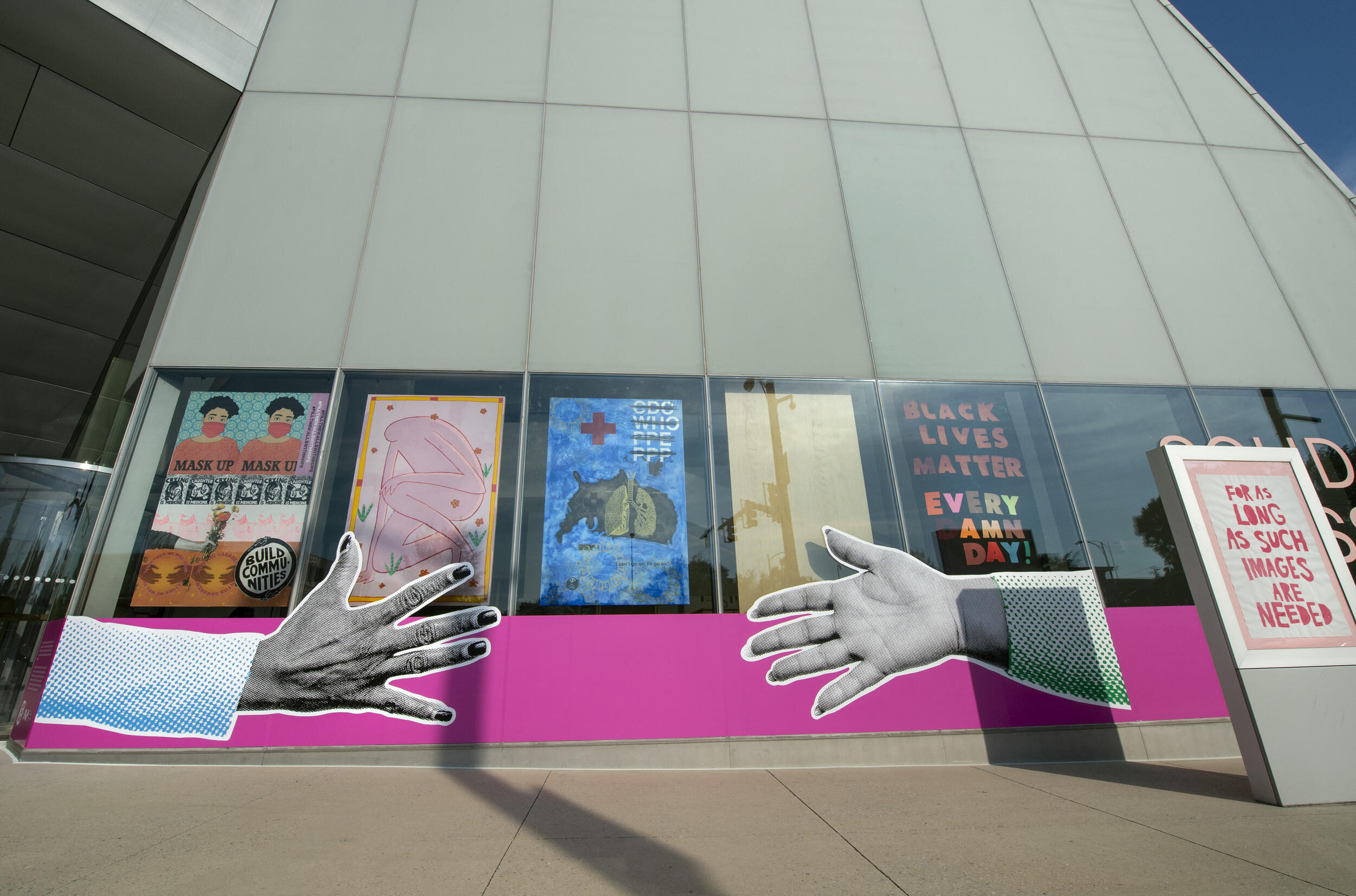 The facade of the Institute for Contemporary Art covered in artwork both on the exterior and in the windows.