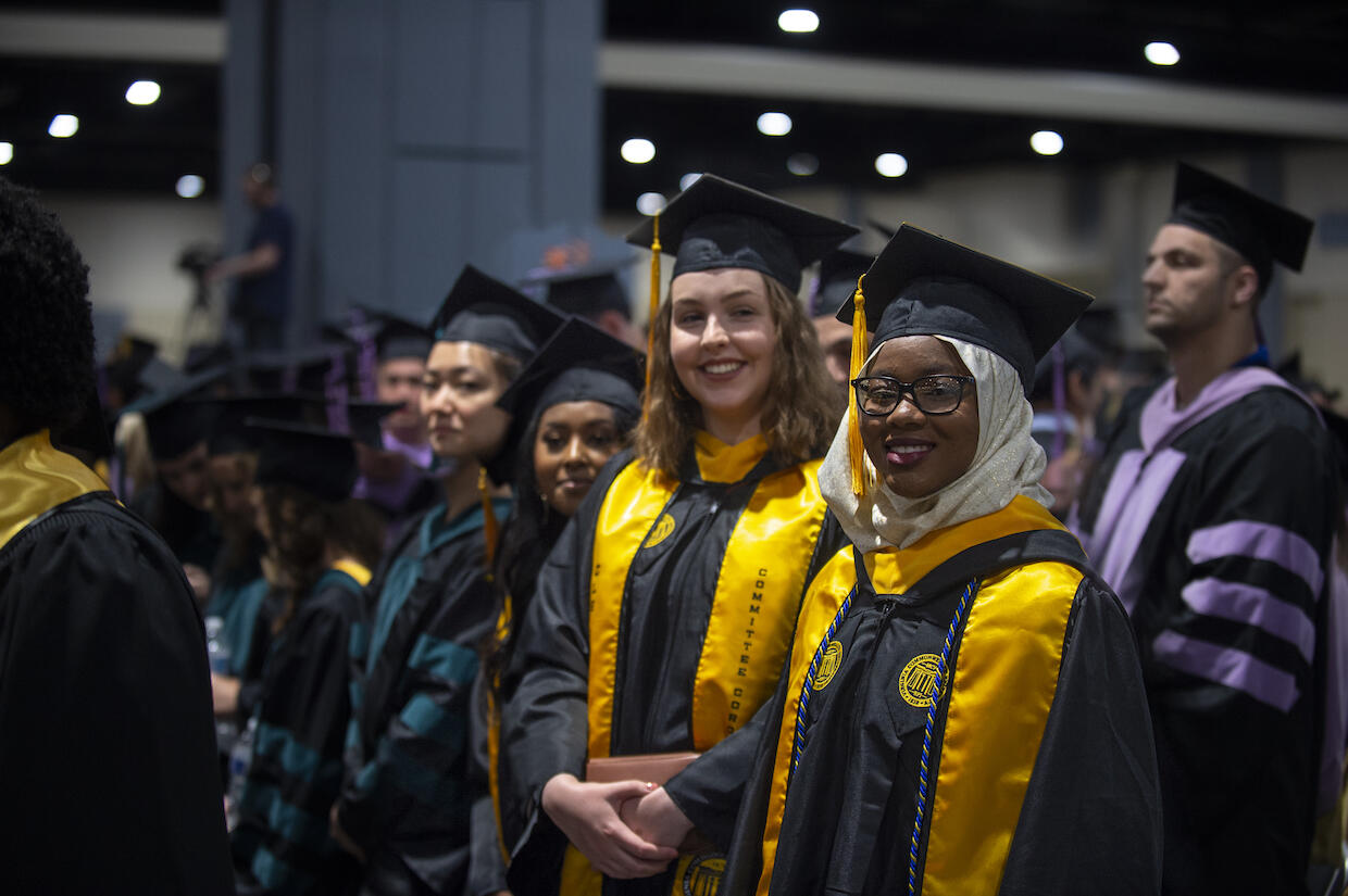 Two VCU graduates stand for a photo at the university's main commencement ceremony May 11 at the Greater Richmond Convention Center.