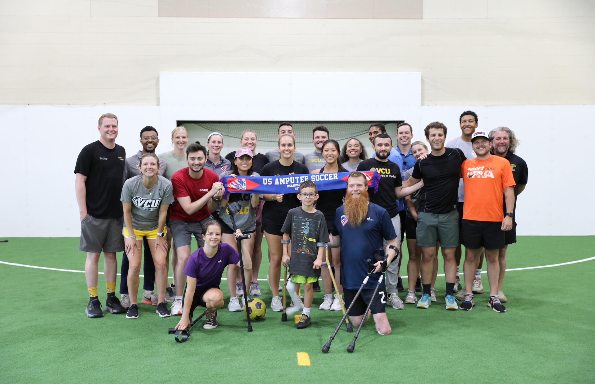 A group photo of 22 adults and one child. 