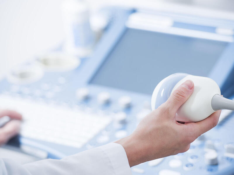 A hand works on a medical machine.