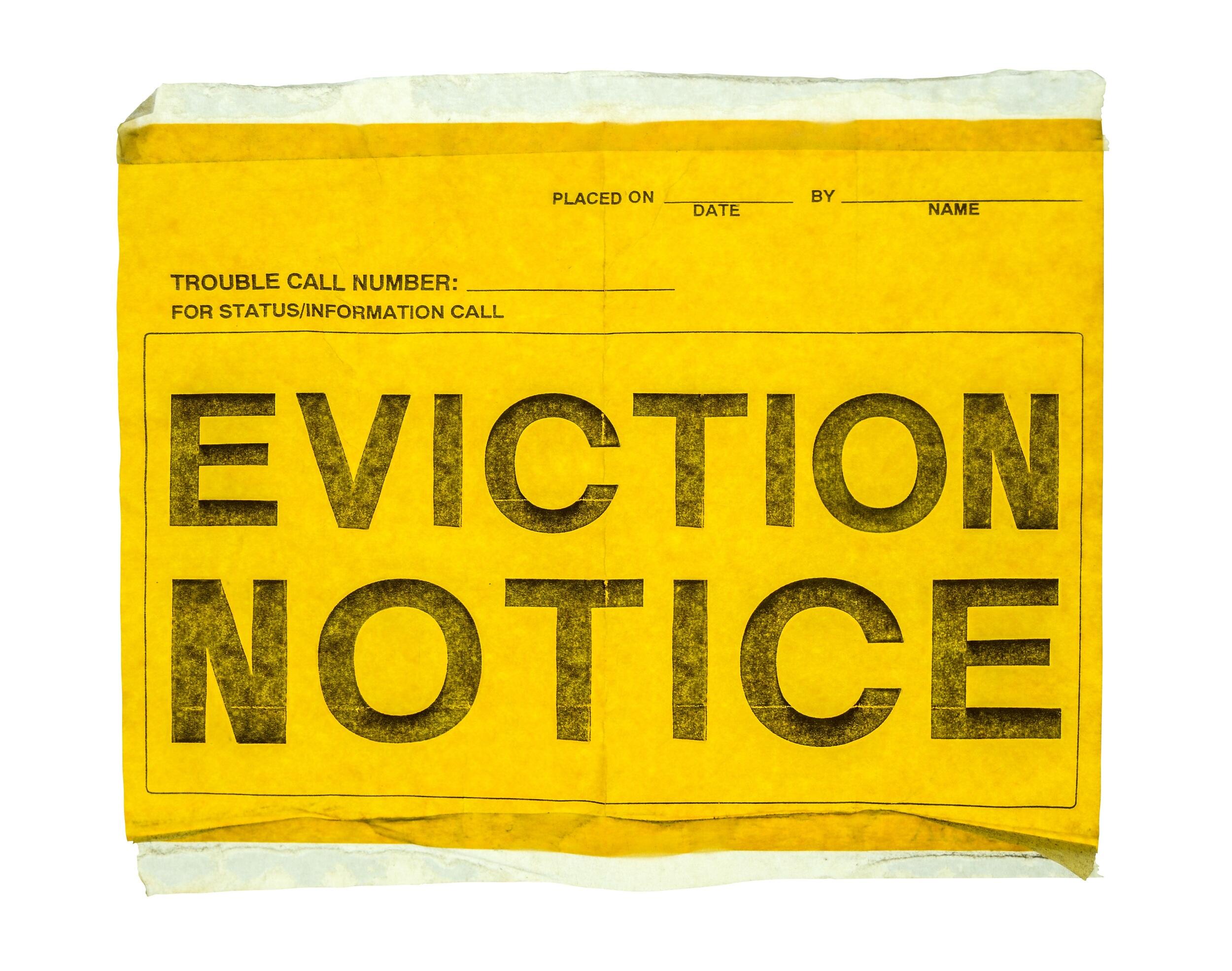 A yellow piece of paper that says \"EVICTION NOTICE\" in bold black letters. 