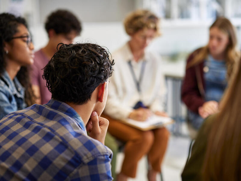 A photo of six people sitting in a semi-circle. 
