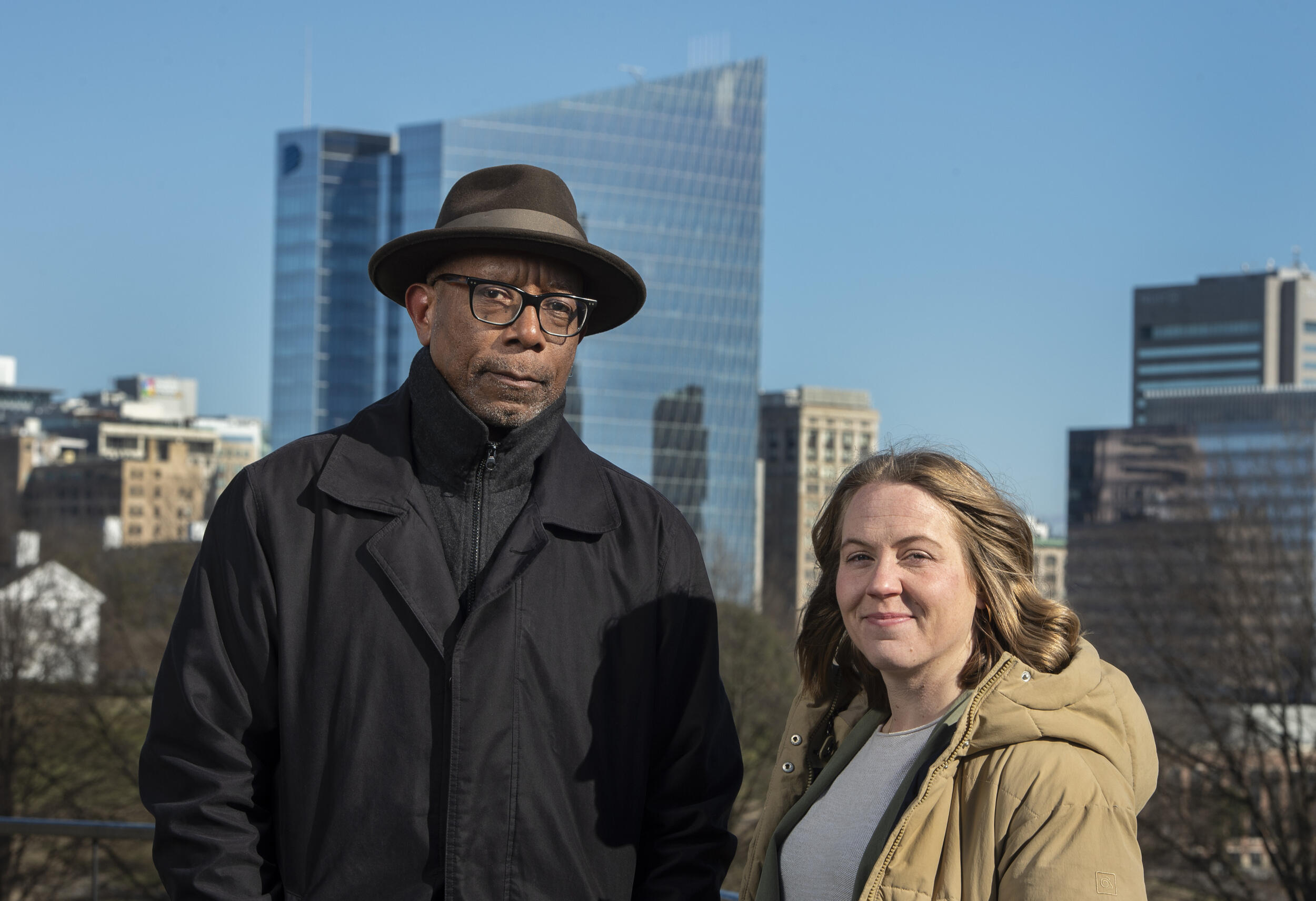 A photo of a man and a woman standing next to each other in front of the Richmond city skyline. 