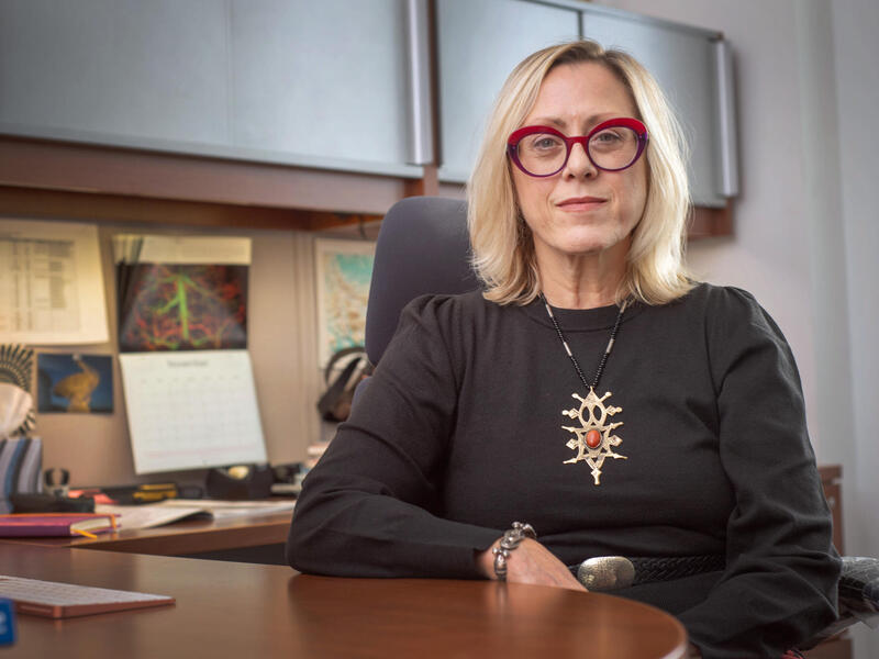 A photo of a woman sitting at a desk. 