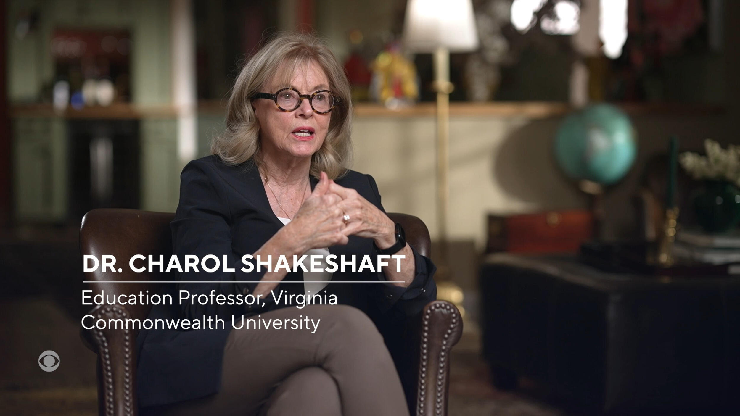 A woman sitting in a dark brown armchair speaking. There is white text that reads \"DR. CHAROL SHAKESHAFT Education Professor, Virginia Commonwealth University\"