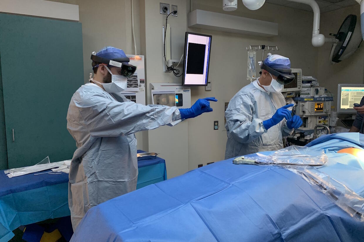Two individuals inside of an operating room.