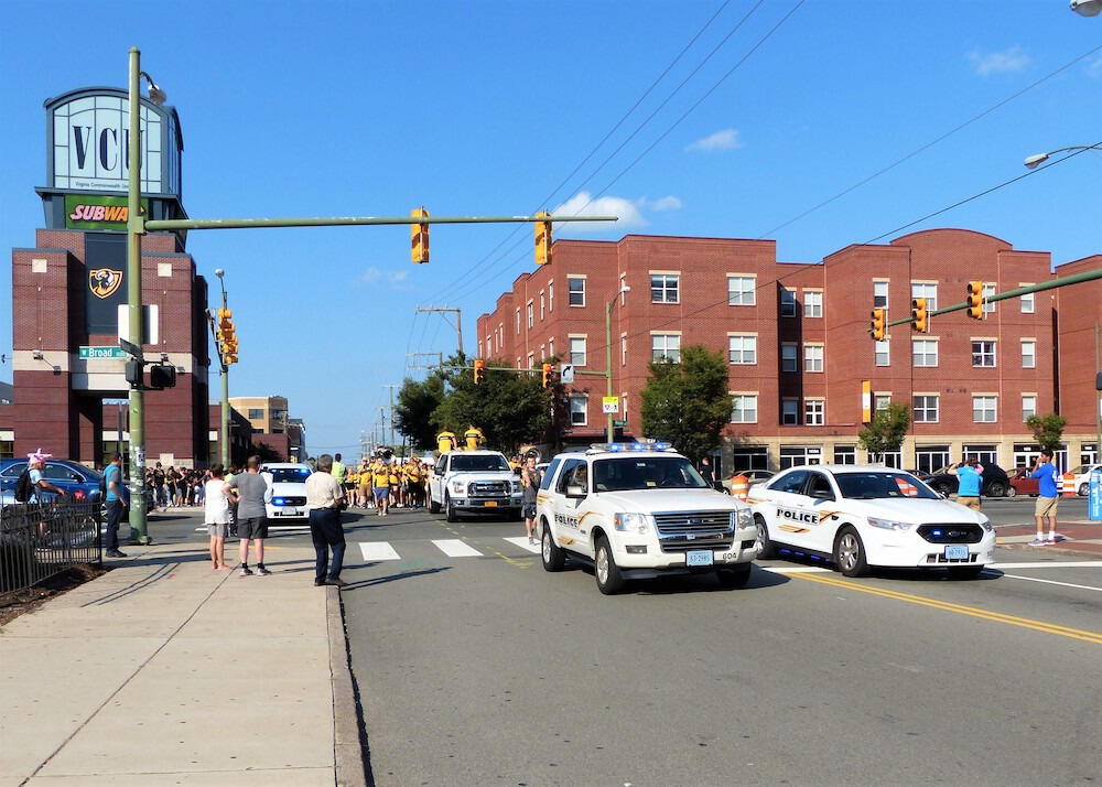 Police trucks lead a parade. 