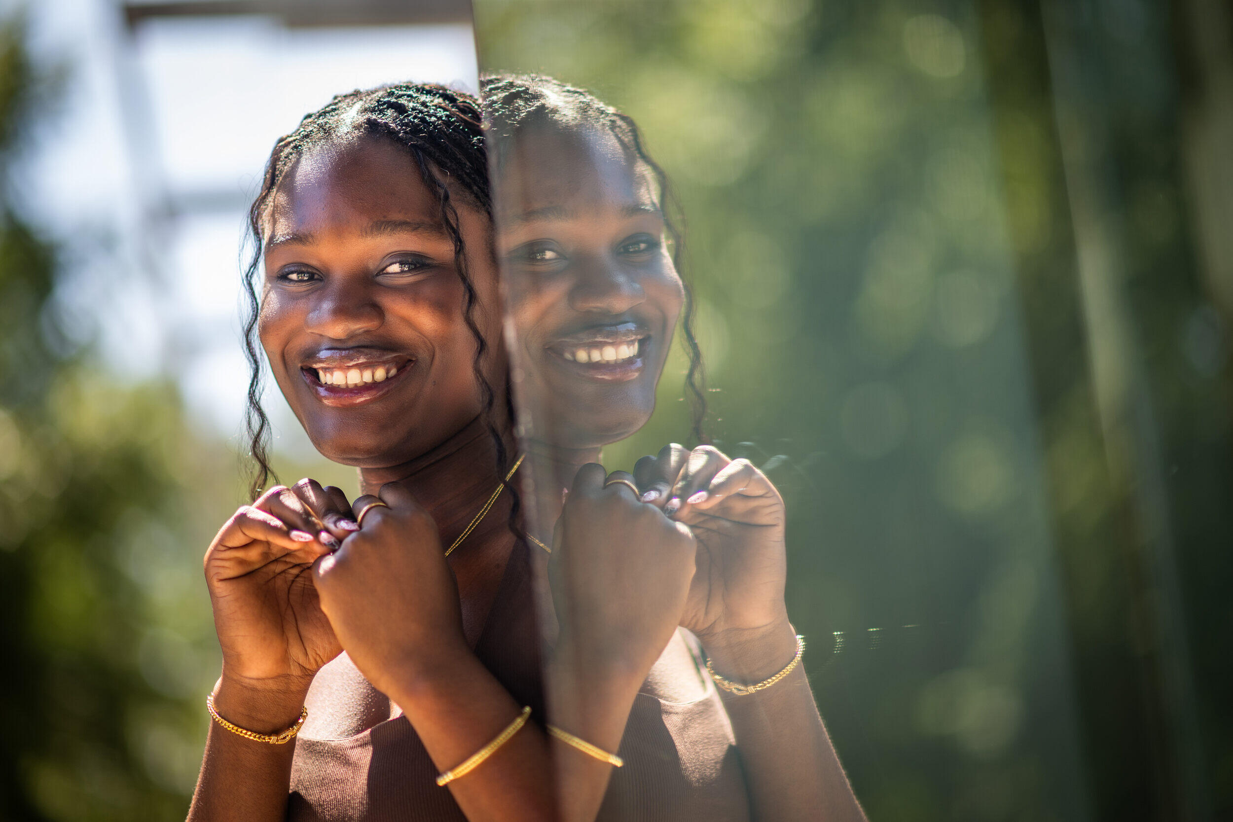 A photo of a woman standing next to a reflection of herself. 