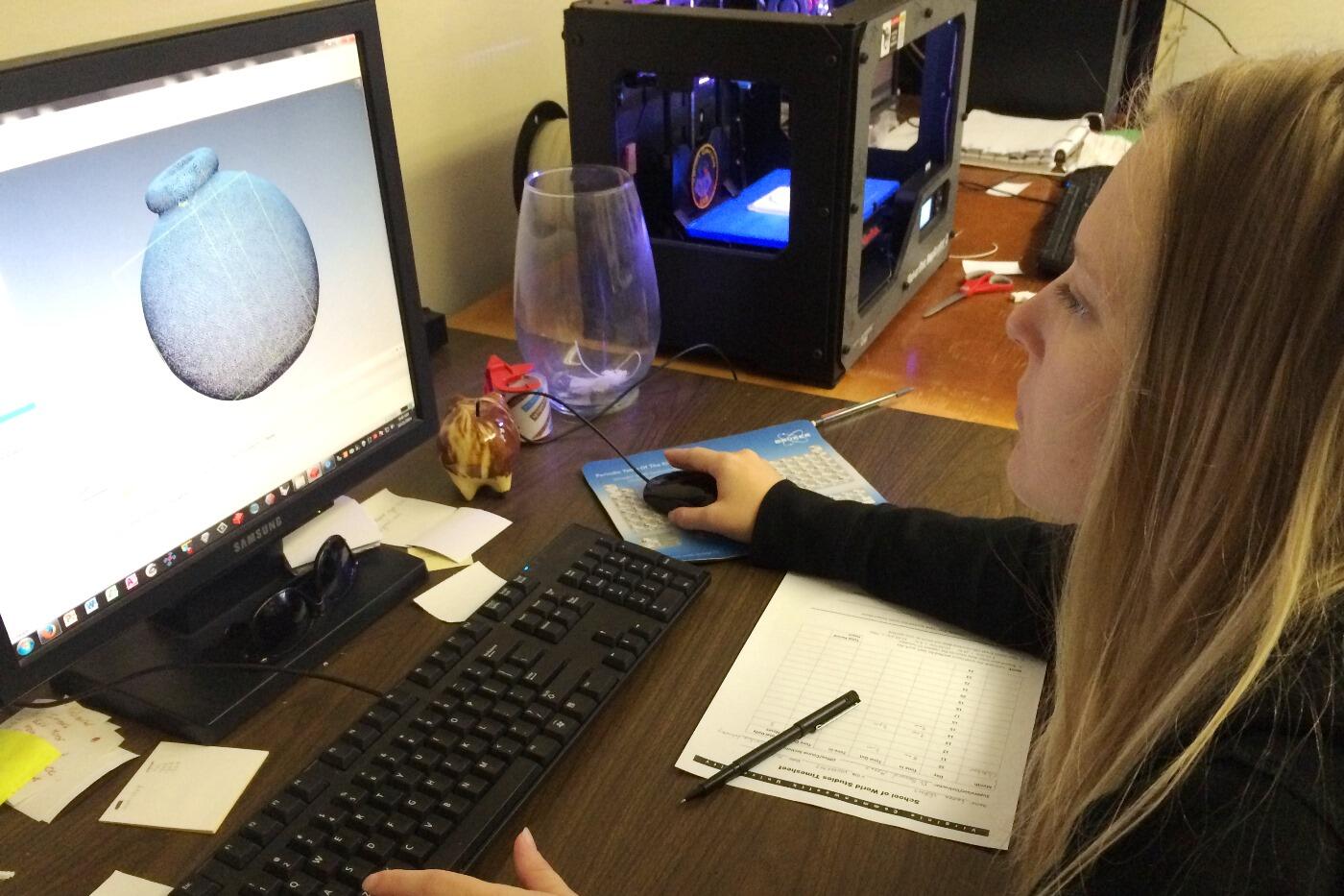VCU graduate Lauren Volkers works on the 3-D scan of the Virginia War Memorial's porcelain Japanese hand grenade. 