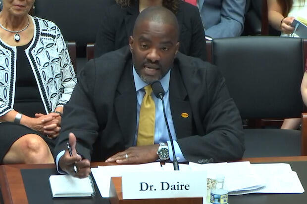 Daire sitting behind desk, speaking to U.S. House of Representatives