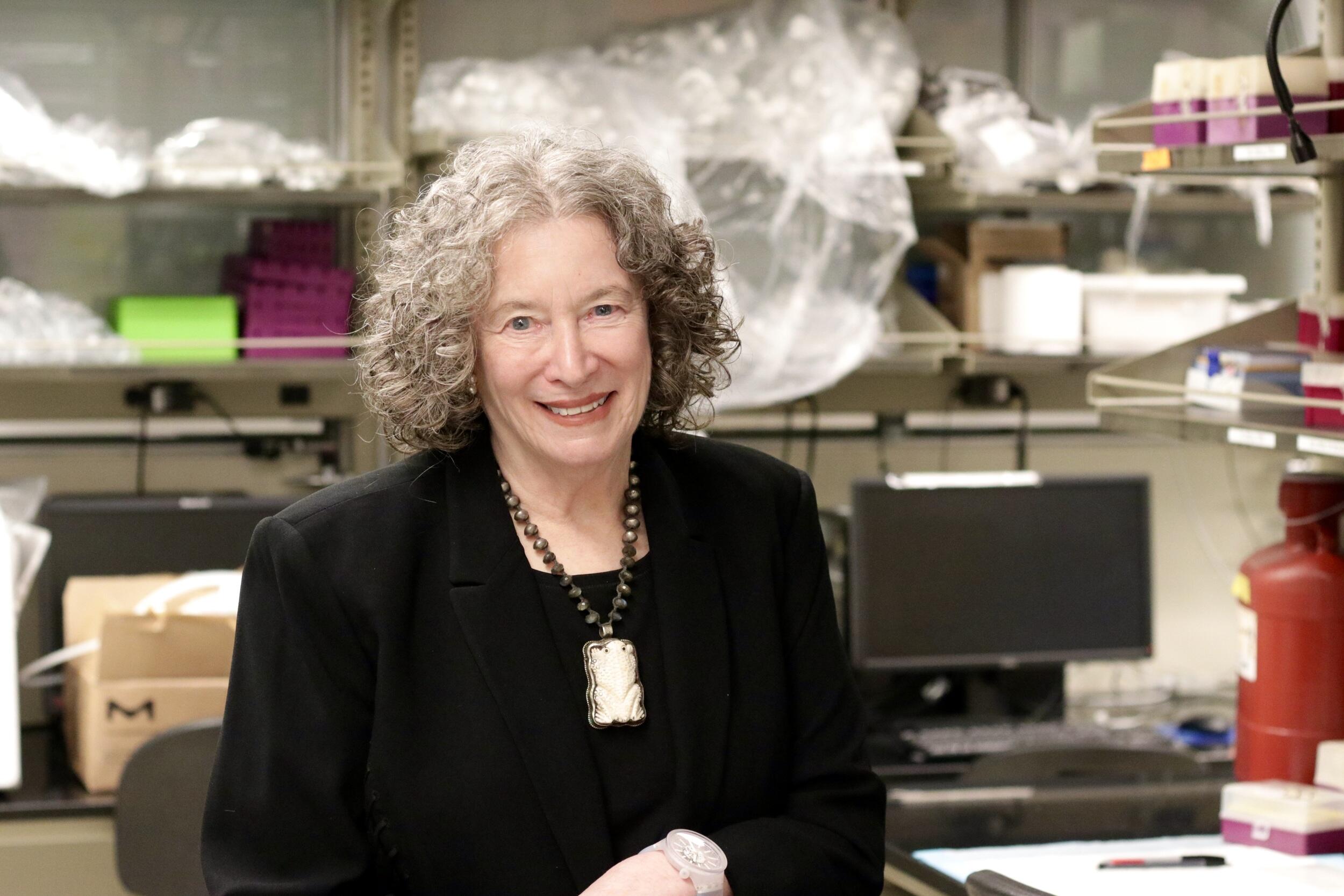 A photo of a woman sitting in a research lab. 