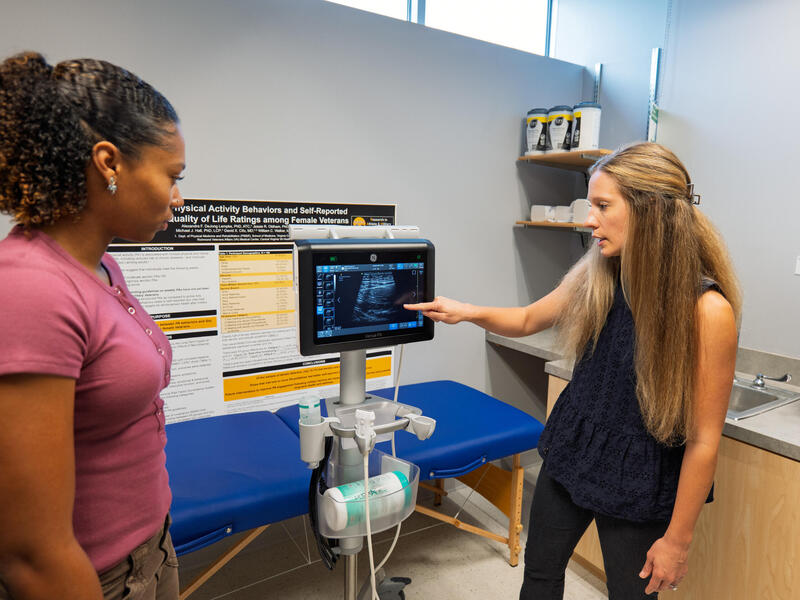 Two women study an ultrasound reading.