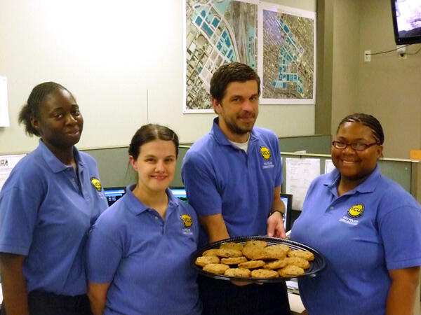 The VCU Police Department honored its 23 communications officers as part of National Public Safety Telecommunications Week (April 8-14.) Dispatchers at the department’s emergency communications center work around the clock every day of the year. They were recognized during their shifts at informal thank-you ceremonies on April 12. Here, day shift dispatcher (Officer In Charge) Kiosha Pollard and evening shift dispatchers Katrina Branchaud, Todd Blair and Tiara Mayo were treated to cookies as a way of showing appreciation. Photo by Mike Porter, VCU Office of Communications and Public Relations.

