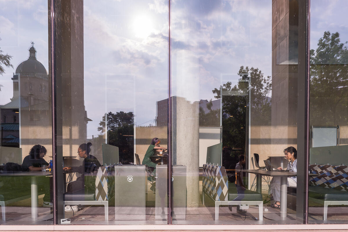 A glass window showing people inside sitting and studying 