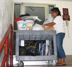 Marissa Seneca organizes her possessions on her cart before taking the items into her dorm room.