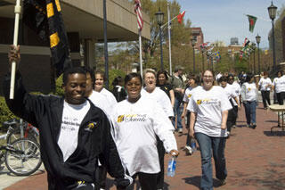Dr. Eric West, VCU fitness and wellness program coordinator, leads participants through the Commons Plaza for walk-a-thon activities at Cary Street Recreational Complex. 