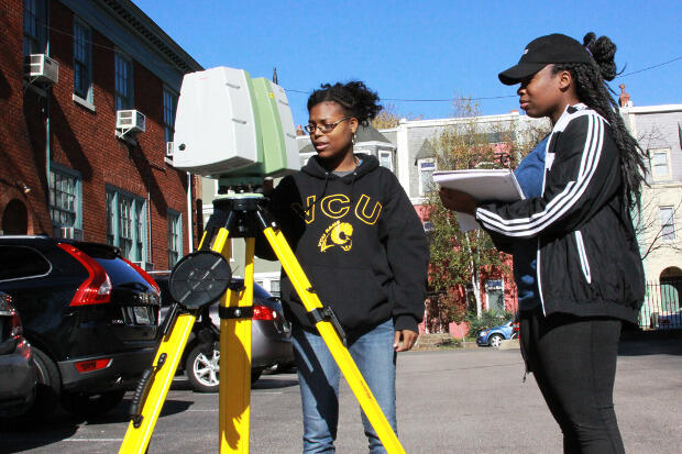 Forensic science majors set up a 3-D scanner to document a reconstructed murder scene.