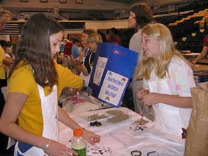 From left: Alexa Hansinger looks at products from Shannon Marwitz's Super Stuff Inc. business. The fourth graders from Swift Creek Elementary School were participants in Mini Market Economy Day at VCU's Siegel Center.

Photo by Malorie Janis, University News Services