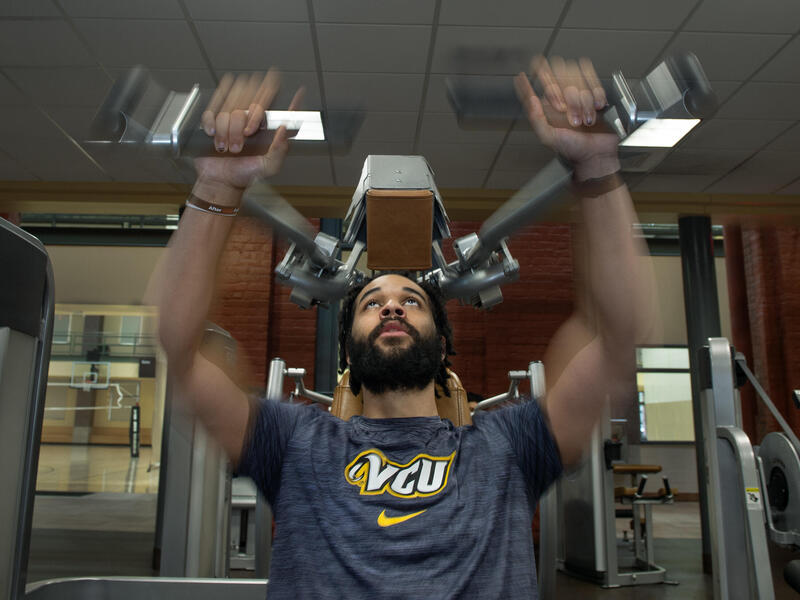 A photo of a man using an exercise machine. 