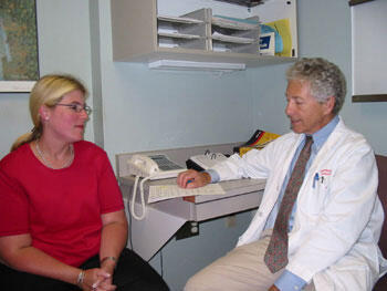 Dr. Harvey Sugerman talks to Linda Hay about her progress during a follow up visit. Hay has lost more than 100 pounds in the seven months since Sugerman performed gastric bypass surgery in November 2002.

Photos by Michael Ford, University News Services