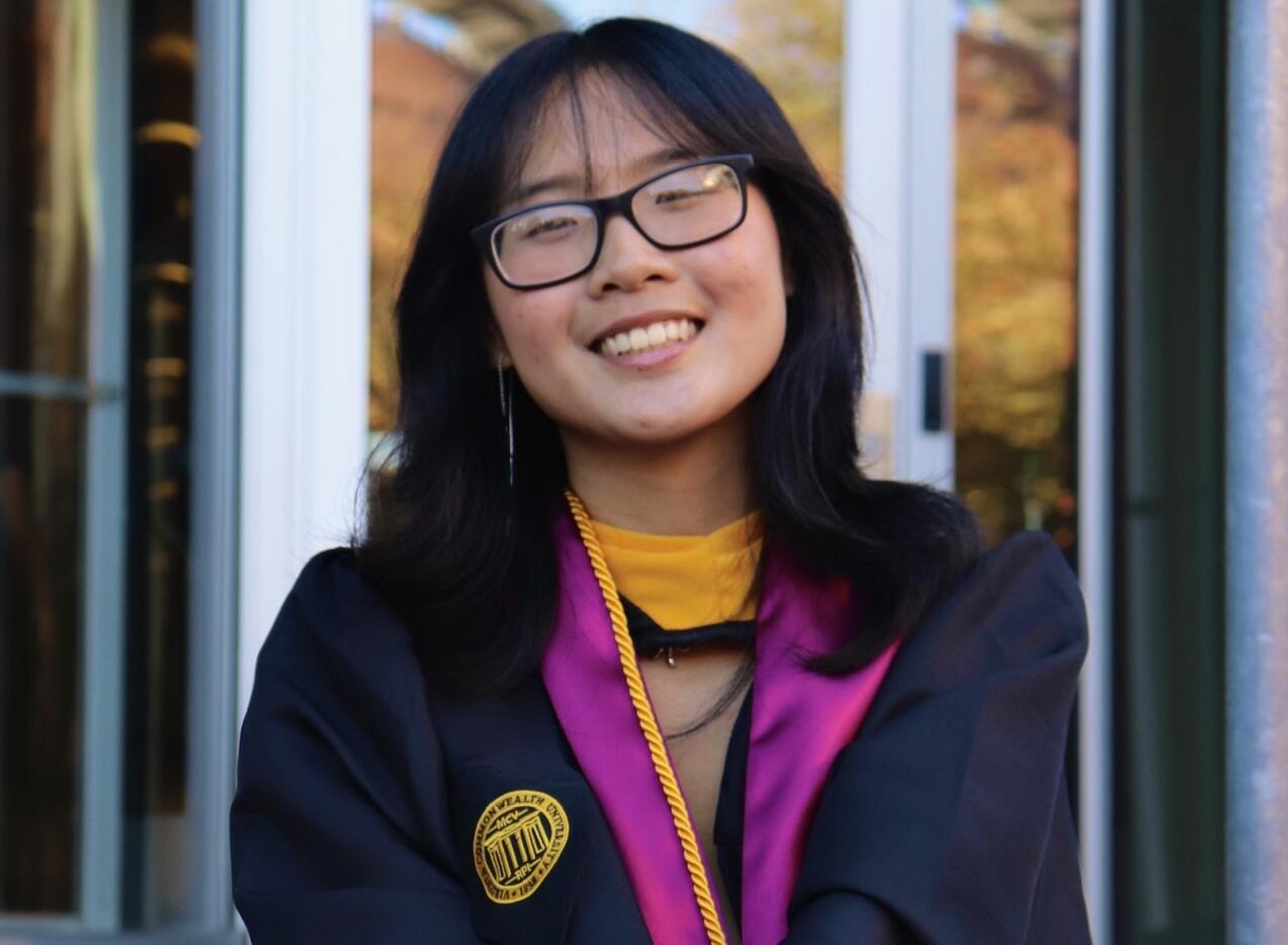 A photo of a woman wearing a graduation gown. 
