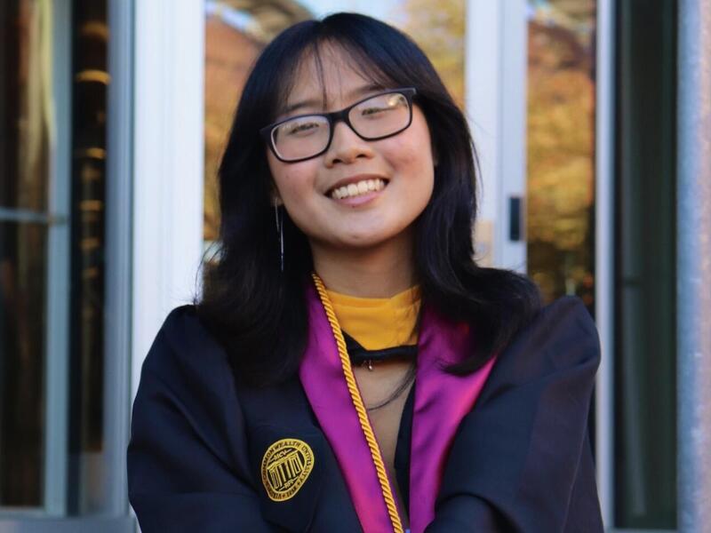 A photo of a woman wearing a graduation gown. 