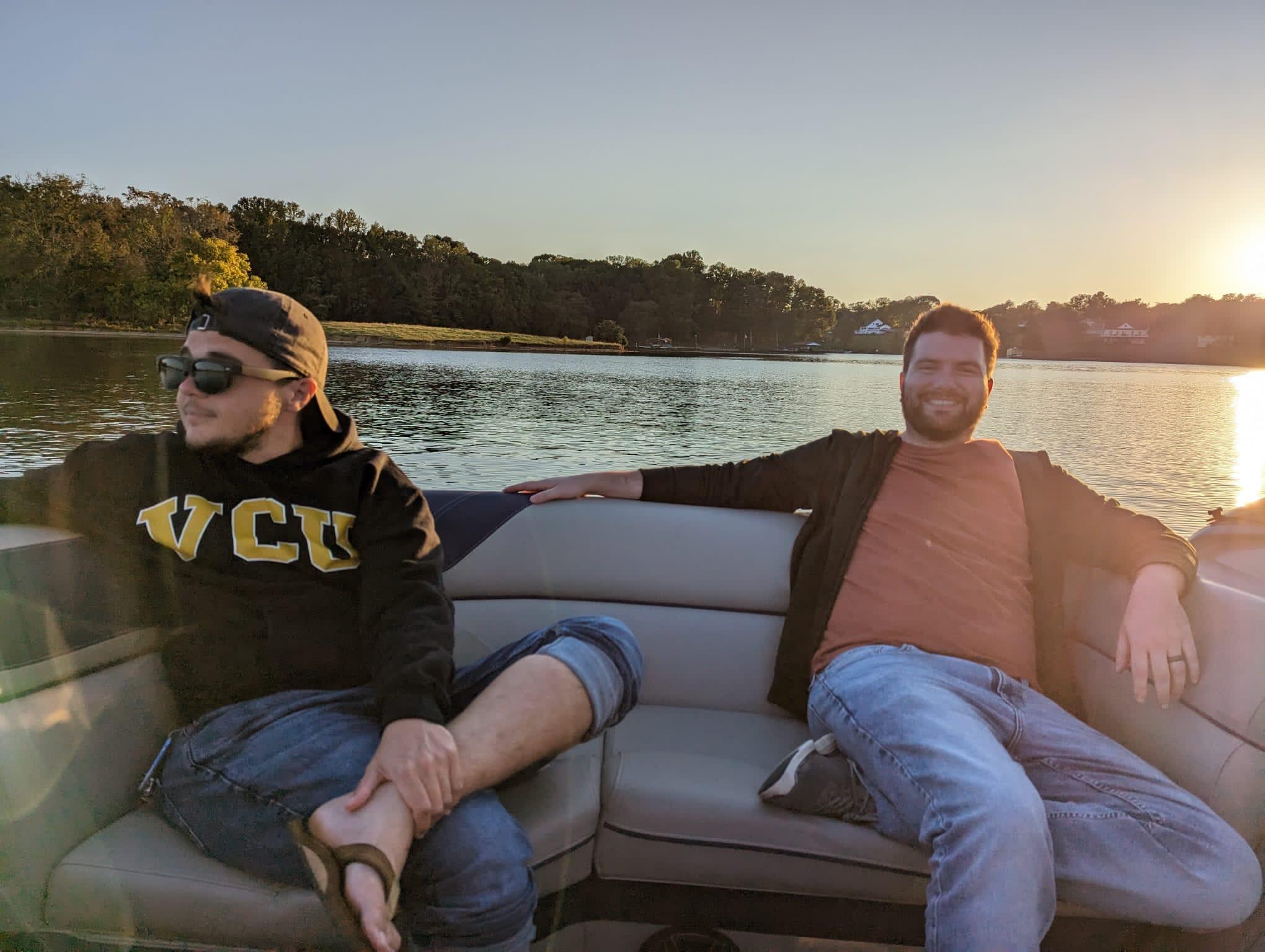 A photo of two men sitting in a boat on a lake. 