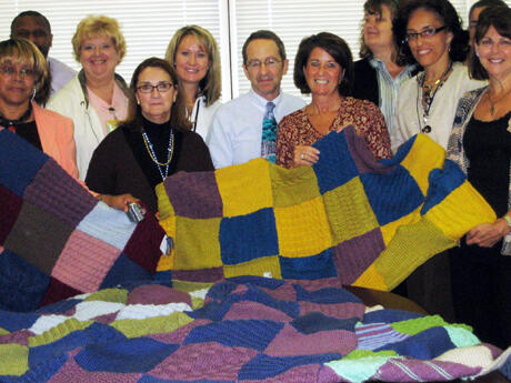 Several women from the Weinstein Jewish Community Center Knitzvah Knitters visited the Virginia Treatment Center for Children at Virginia Commonwealth University in September to donate eight hand-made comfort blankets for the children. Back row, L-R, Larry Robinson, Nancy Doyle, Jennifer DeSanto, Norm Geller, Lynn Swartz (JCC), Jean Hovey-Murray (VTCC Advisory Council Chairman) Front:  Delores Richards-Madikiza, Linda Bradford, Lynn Swartz, Stephanie Spencer, Rhona Arenstein (JCC). Photo by Sathya Achia Abraham, VCU Communications and Public Relations