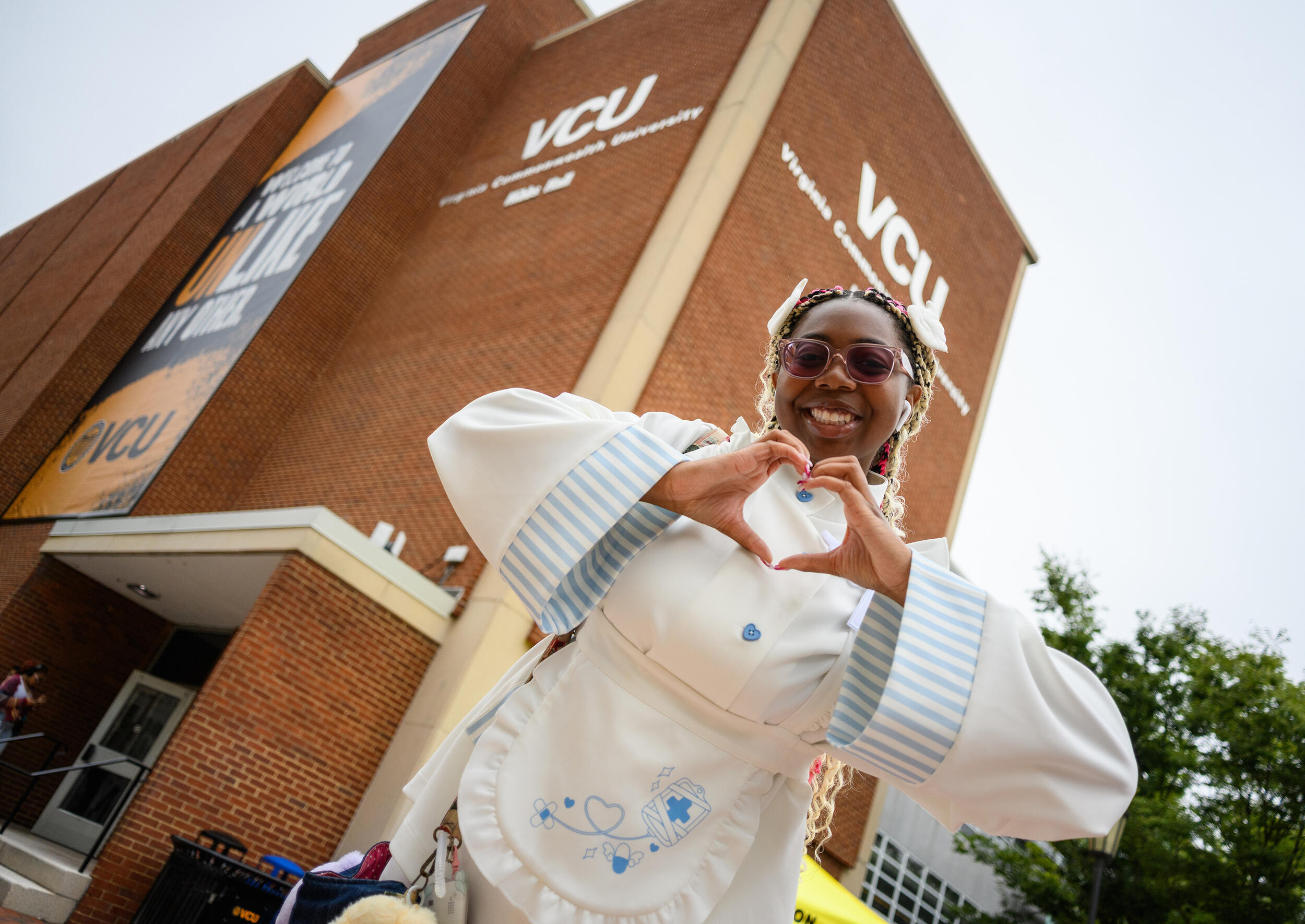 A photo of a woman making a heart with her hands. 