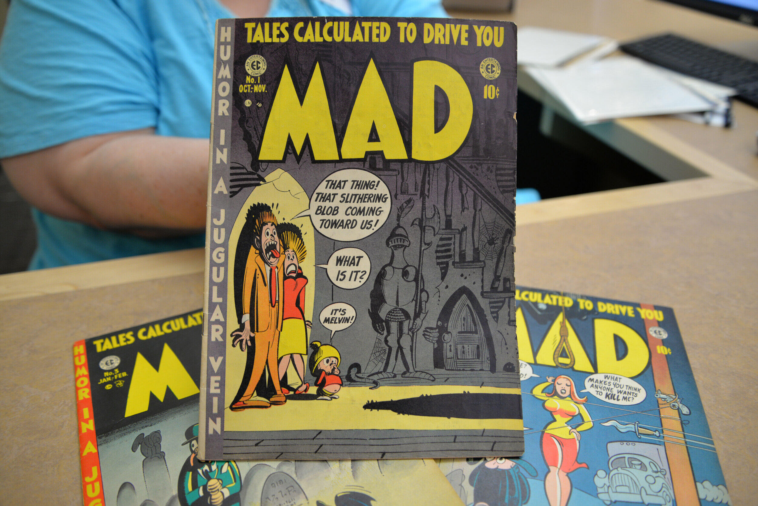 Three Mad magazine editions displayed on a countertop.