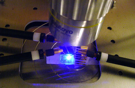 A blue light emitting diode (LED) in operation. A yellow dye is pumped by the blue LED, which together produces the white light that is used in lighting applications. Photo courtesy of Ümit Özgür/VCU.