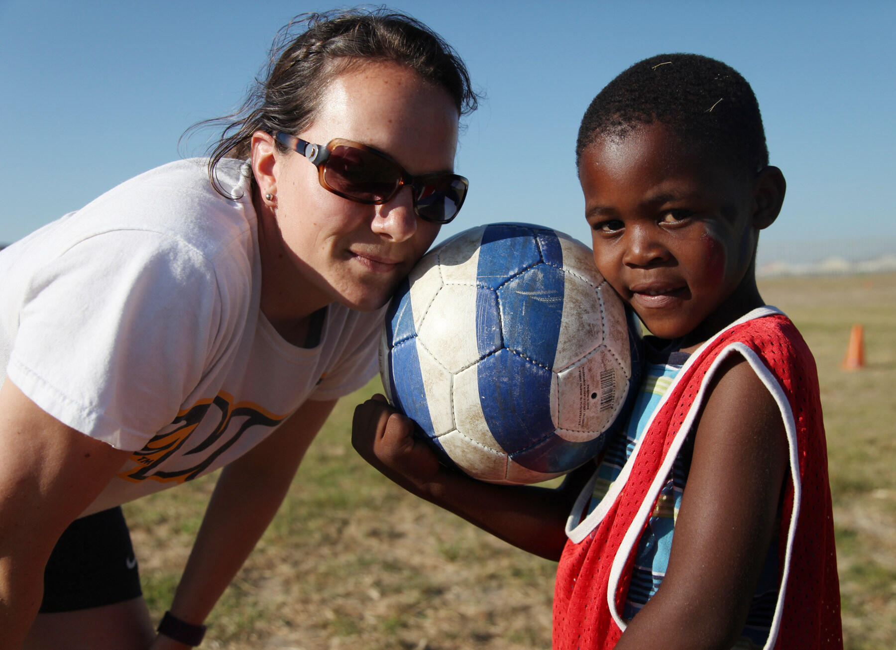Carrie LeCrom, Ph.D., with a boy in South Africa during a previous sports diplomacy trip. (Courtesy Photo)