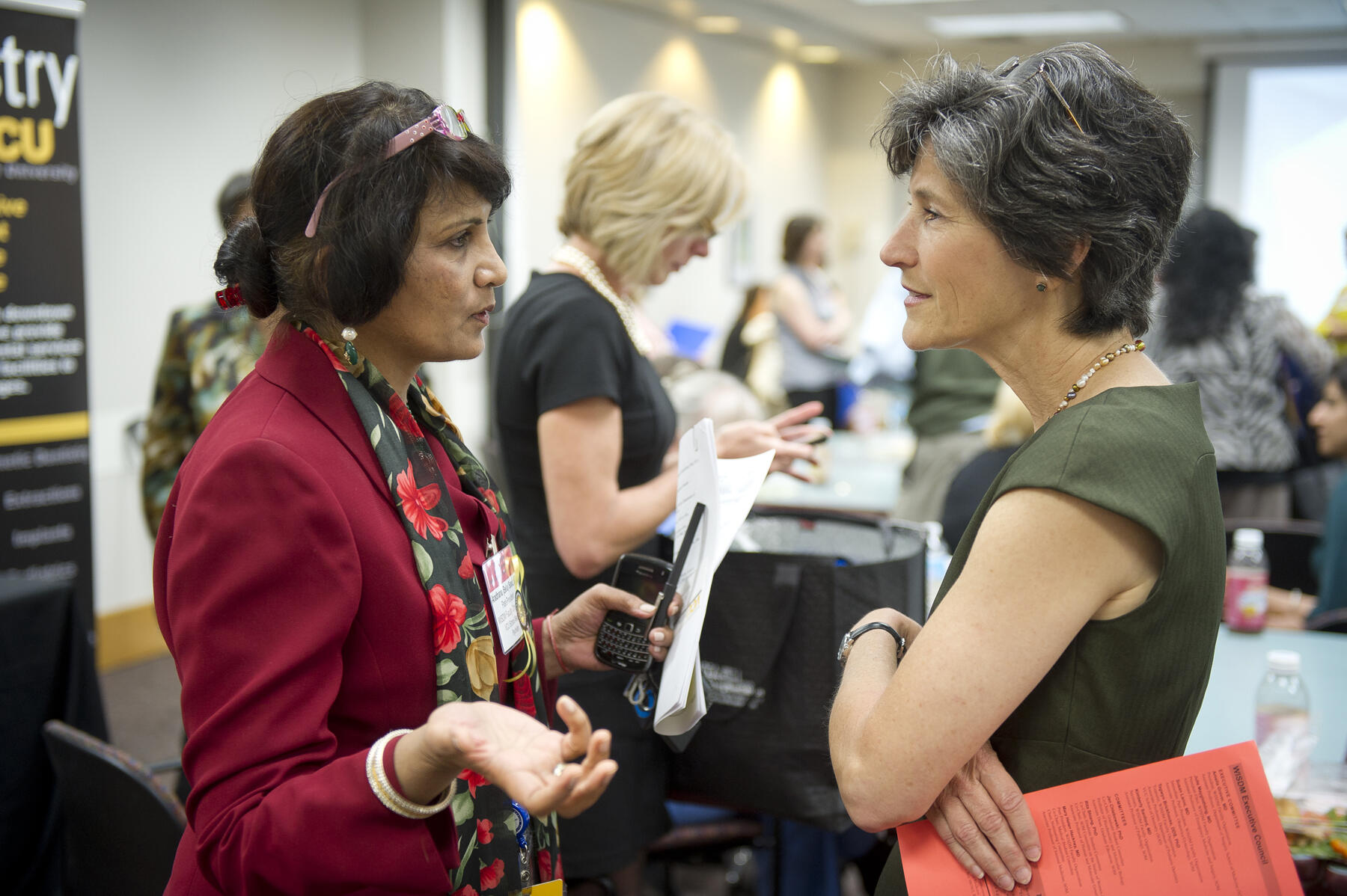 Cathy Howard, left, speaking with an attendee of an event.