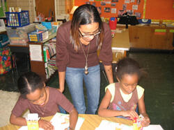 Drawing on experience: VCU senior Adiam Redae (center) helps Oak Grove Elementary students Imani Seymour (left) and Tyonne Singleton (right) as they draw pictures of someone they look up to.  Redae is president of VCU’s “Powerful Beyond Measure” group. Photo by:  Mike Porter/VCU Office of University News Services.