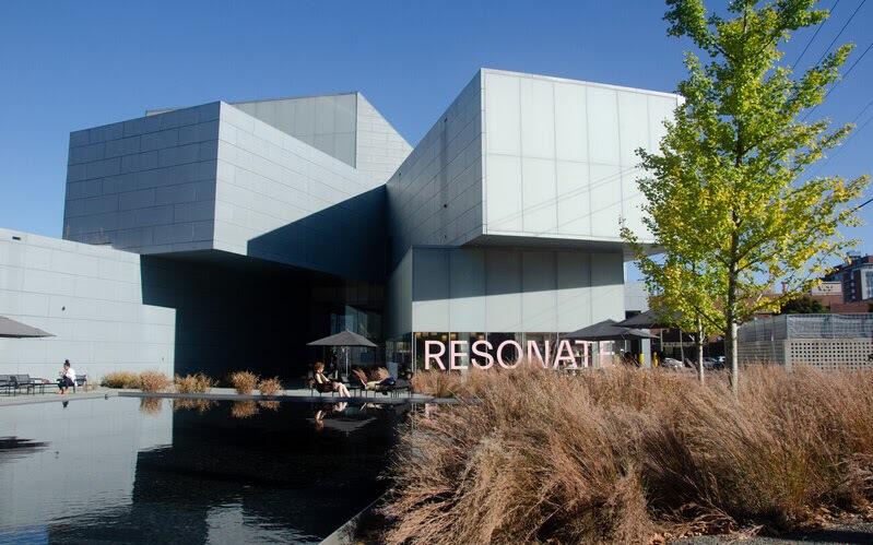 A picture of the Institute for Contemporary Art with the word \"RESONATE\" written across the bottom level's window in pink letters. 
