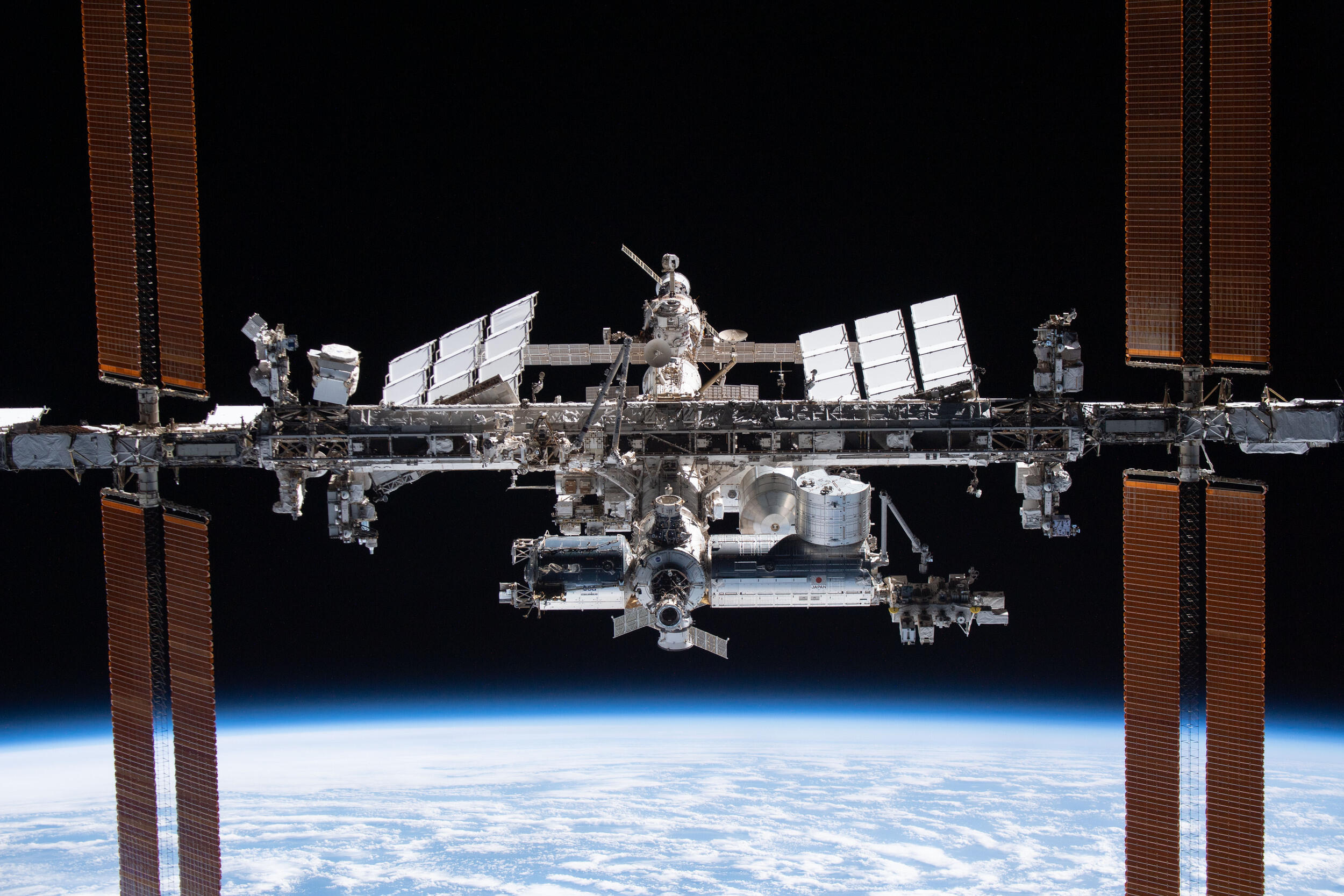 A photo of the International Space Station floating above earth. 