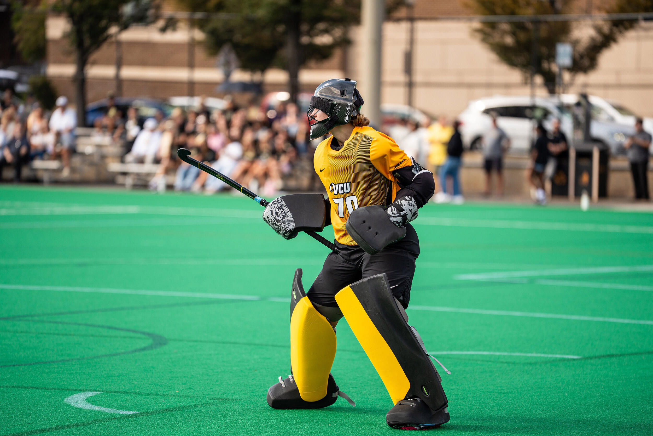 A photo of a field hockey player standing on a field. 