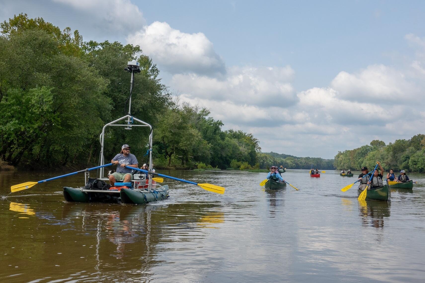 VCU students paddle alongside a Terrain360 boat that generated a panoramic virtual tour of an 11-mile stretch of the Middle James River studied by the students