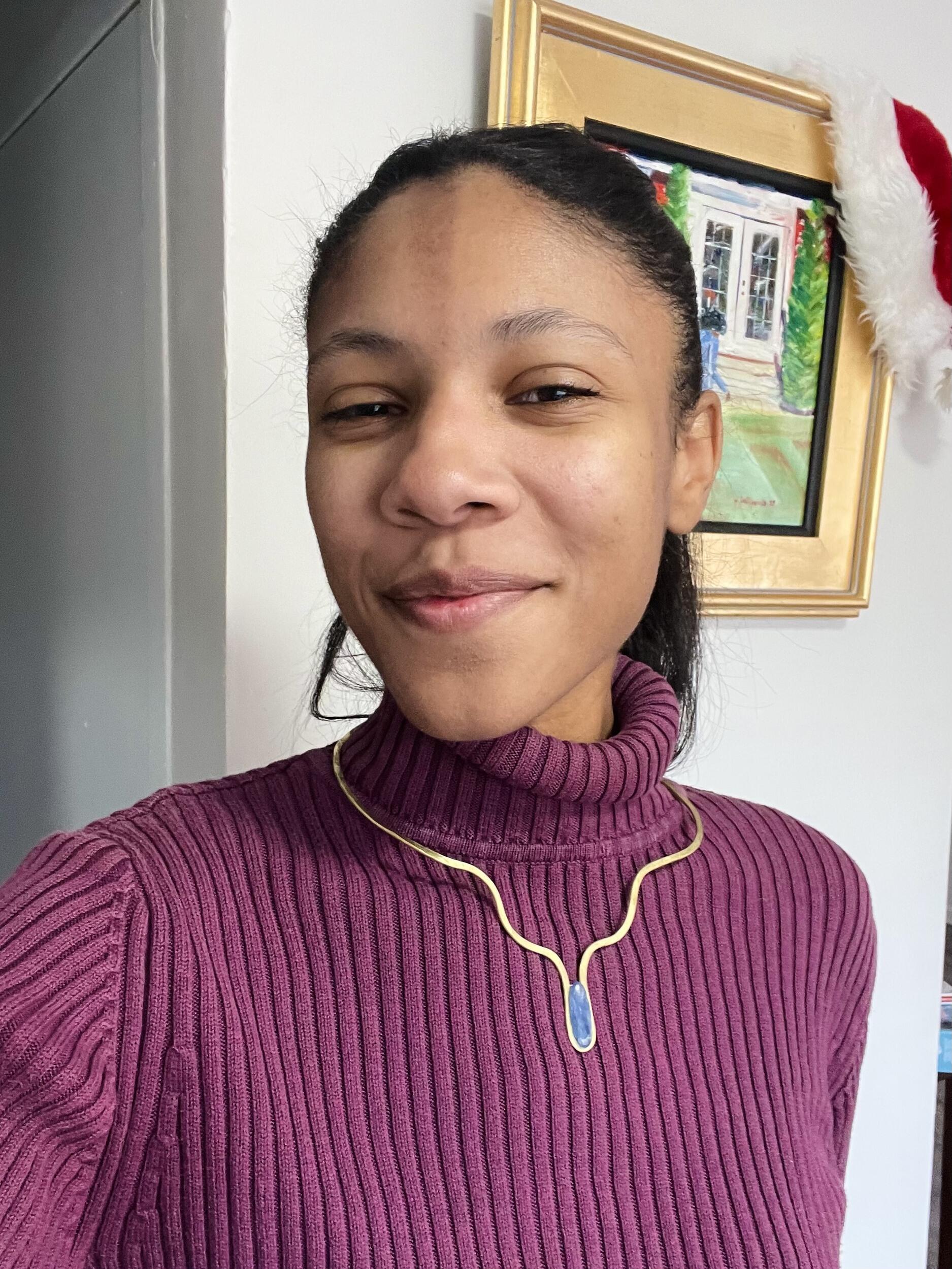 A photo of a woman wearing a gold necklace. 